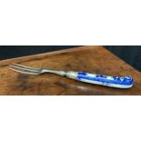 A Saint Cloud porcelain fork handle, pistol grip, painted in underglaze blue with scrolls, steel