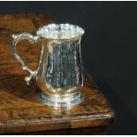 A George III silver bell shaped half pint mug, foliate scroll-capped handle, skirted base, 10cm