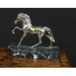 A Continental parcel-gilt silver coloured metal model, of a horse, prancing, filled, canted