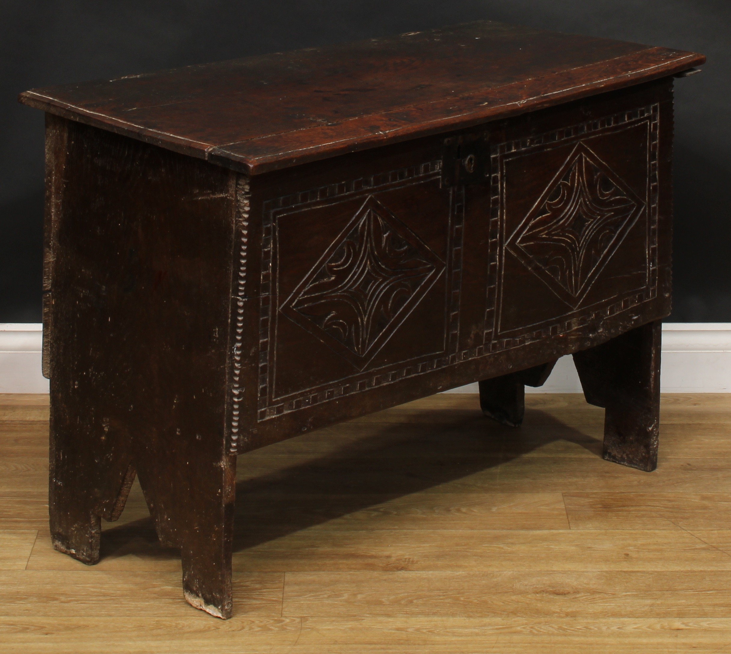 A 17th century elm six plank chest, hinged top enclosing a till, the front carved with leafy - Image 2 of 5