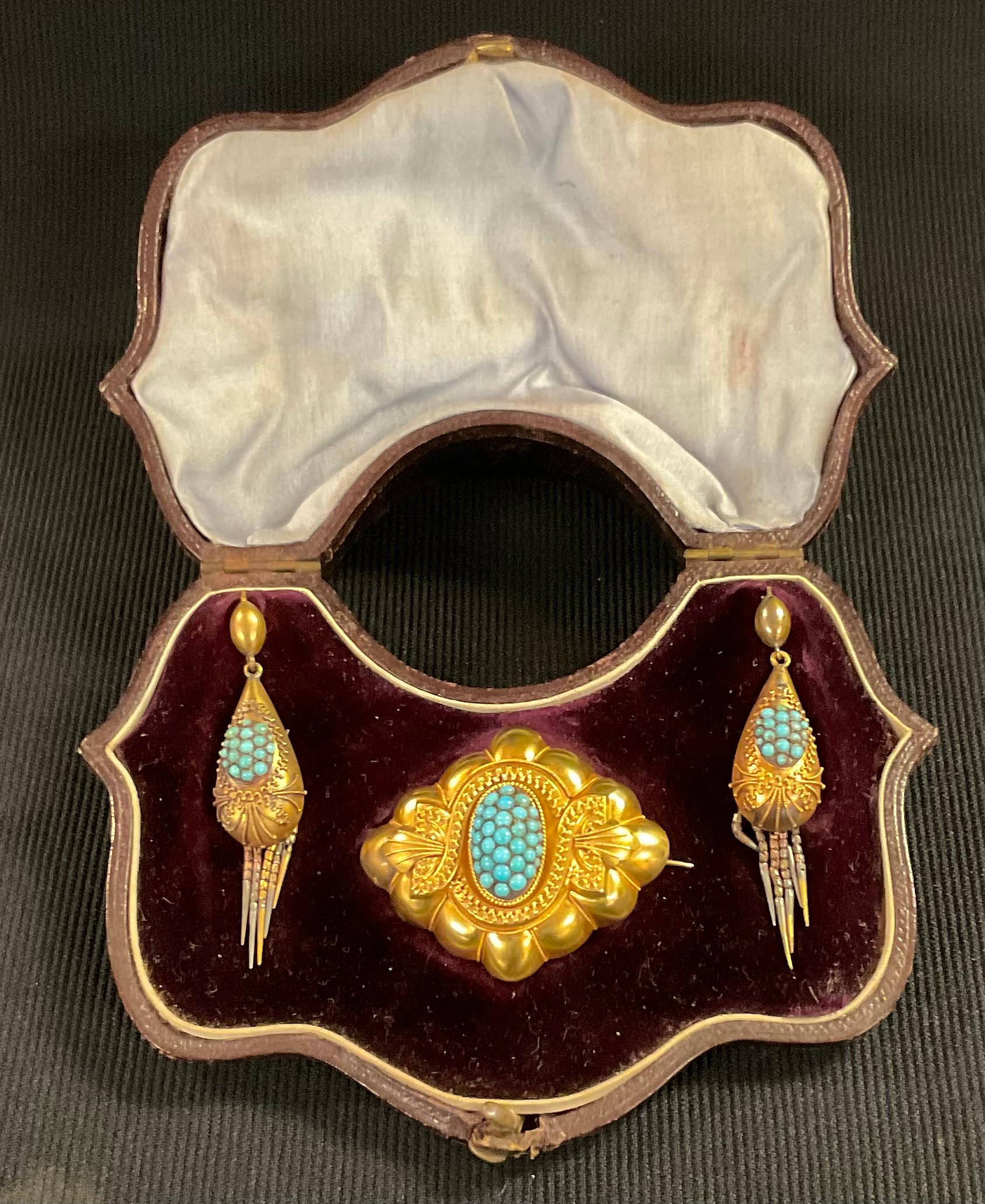 A Victorian turquoise brooch and earring suite, the oval brooch set with a cluster of circular