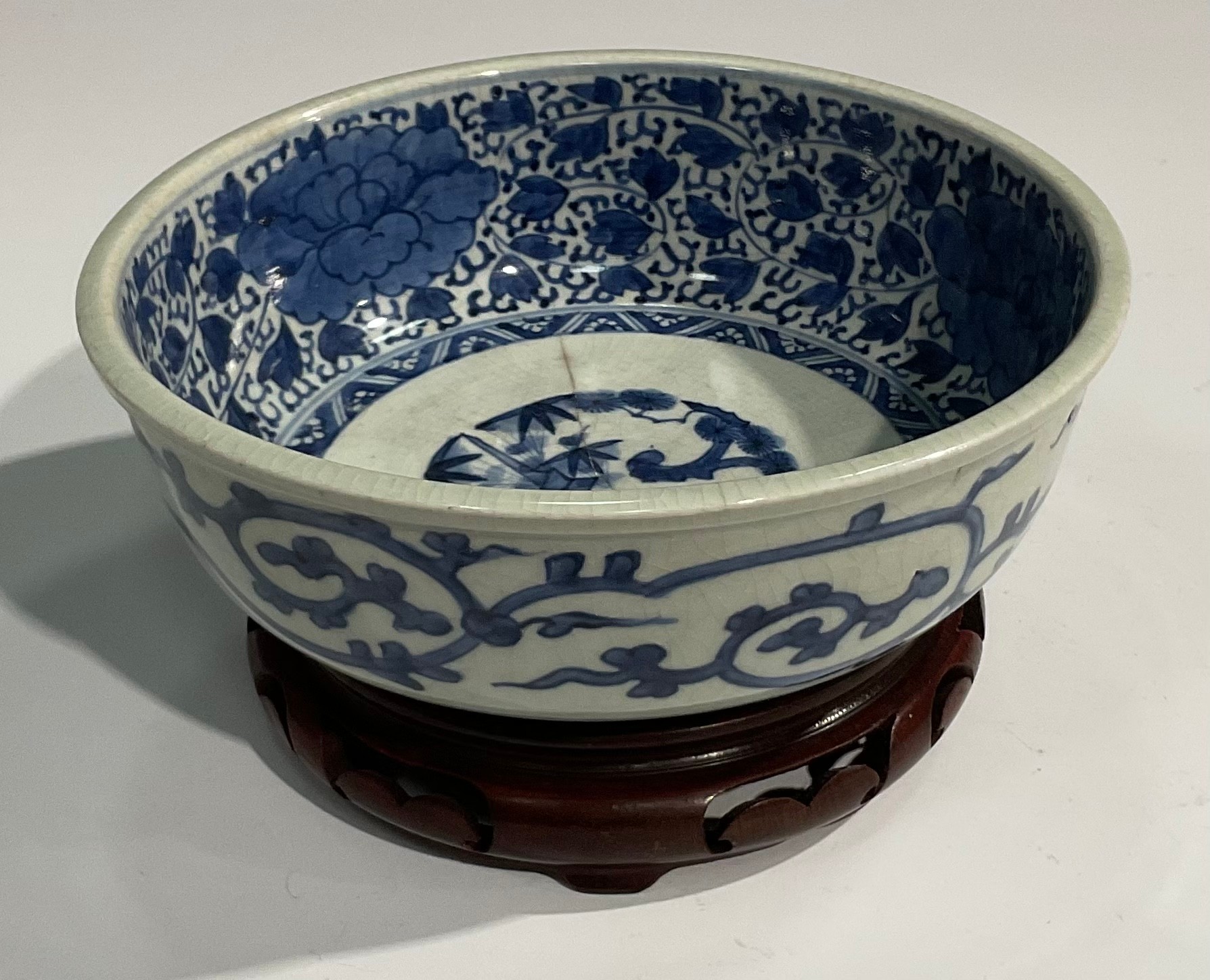 A Chinese circular bowl, painted in tones of underglaze blue with prunus, chrysanthemums and - Image 2 of 5