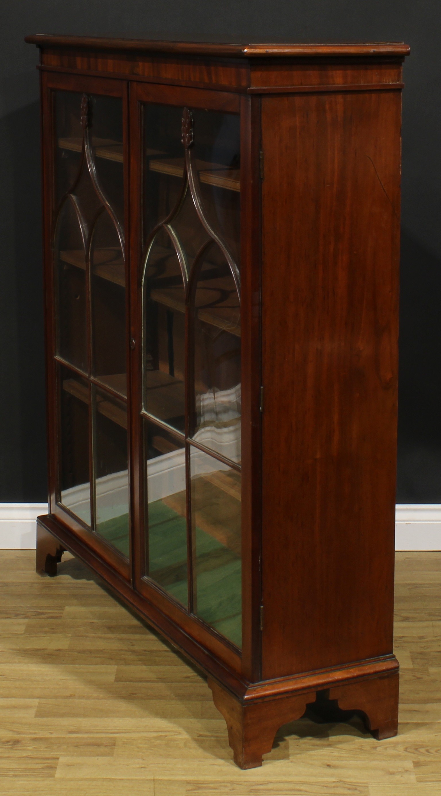 A 19th century mahogany low library bookcase, oversailing top above a pair of glazed doors enclosing - Image 4 of 5