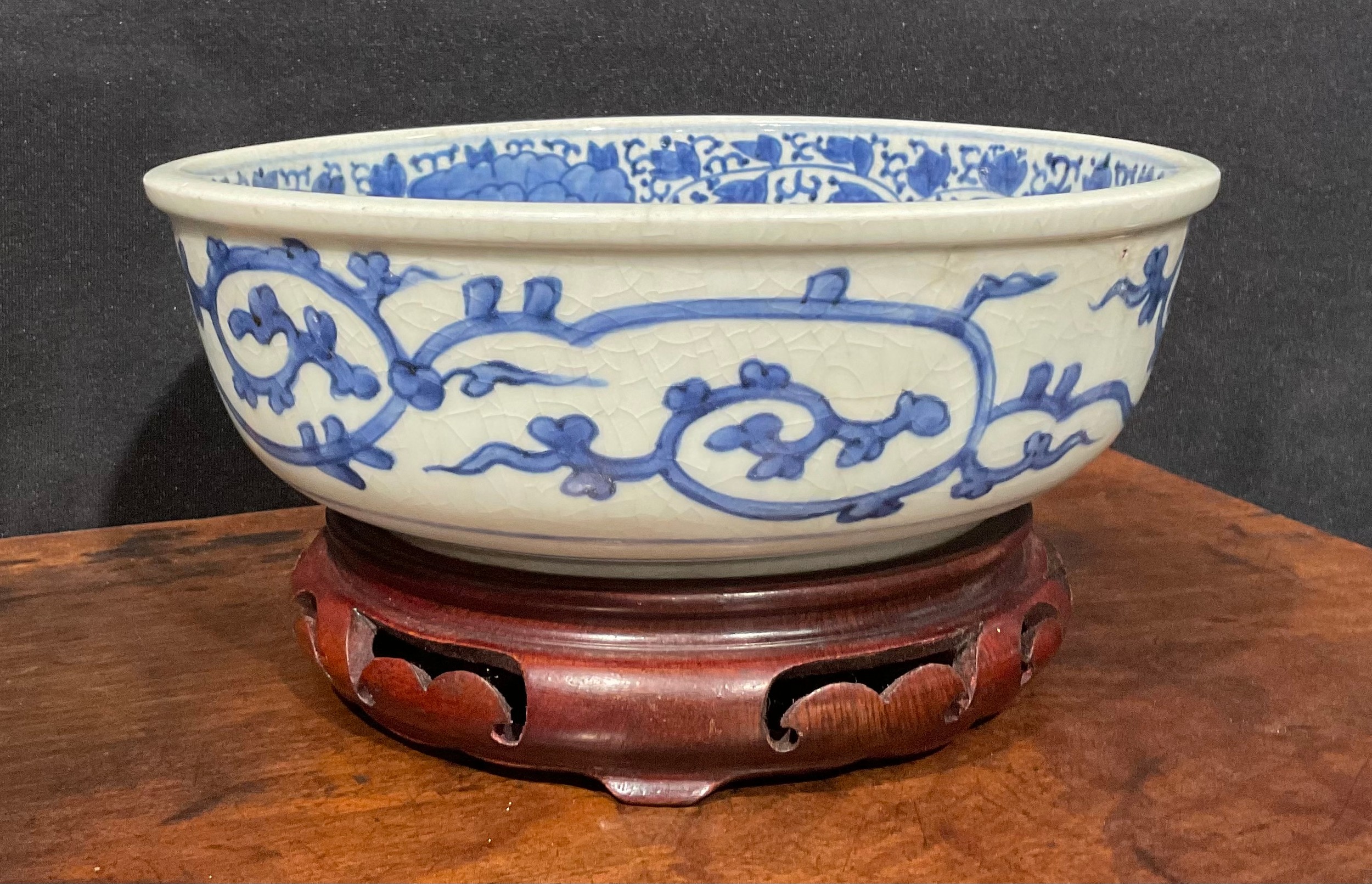 A Chinese circular bowl, painted in tones of underglaze blue with prunus, chrysanthemums and