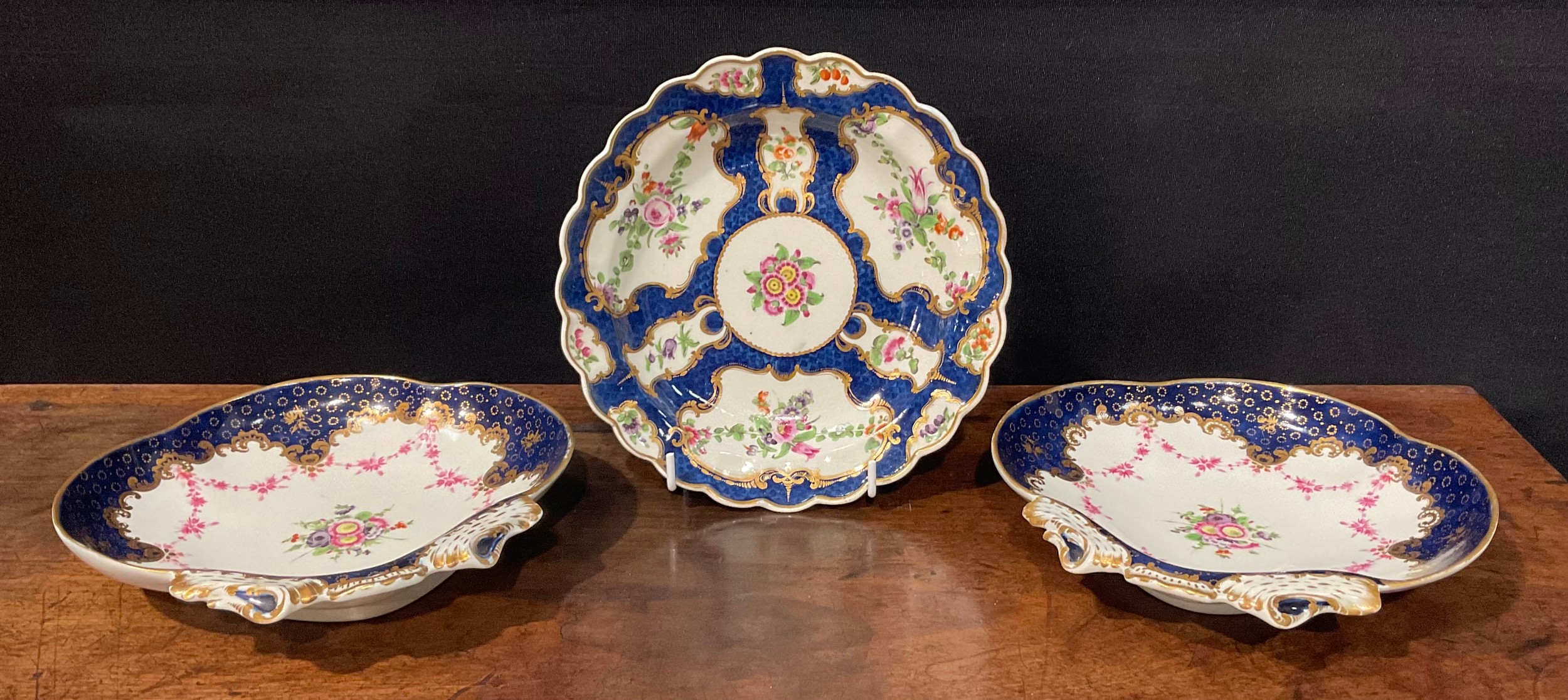 A pair of Worcester shell shaped dessert dishes, painted with floral bouquet and pink floral