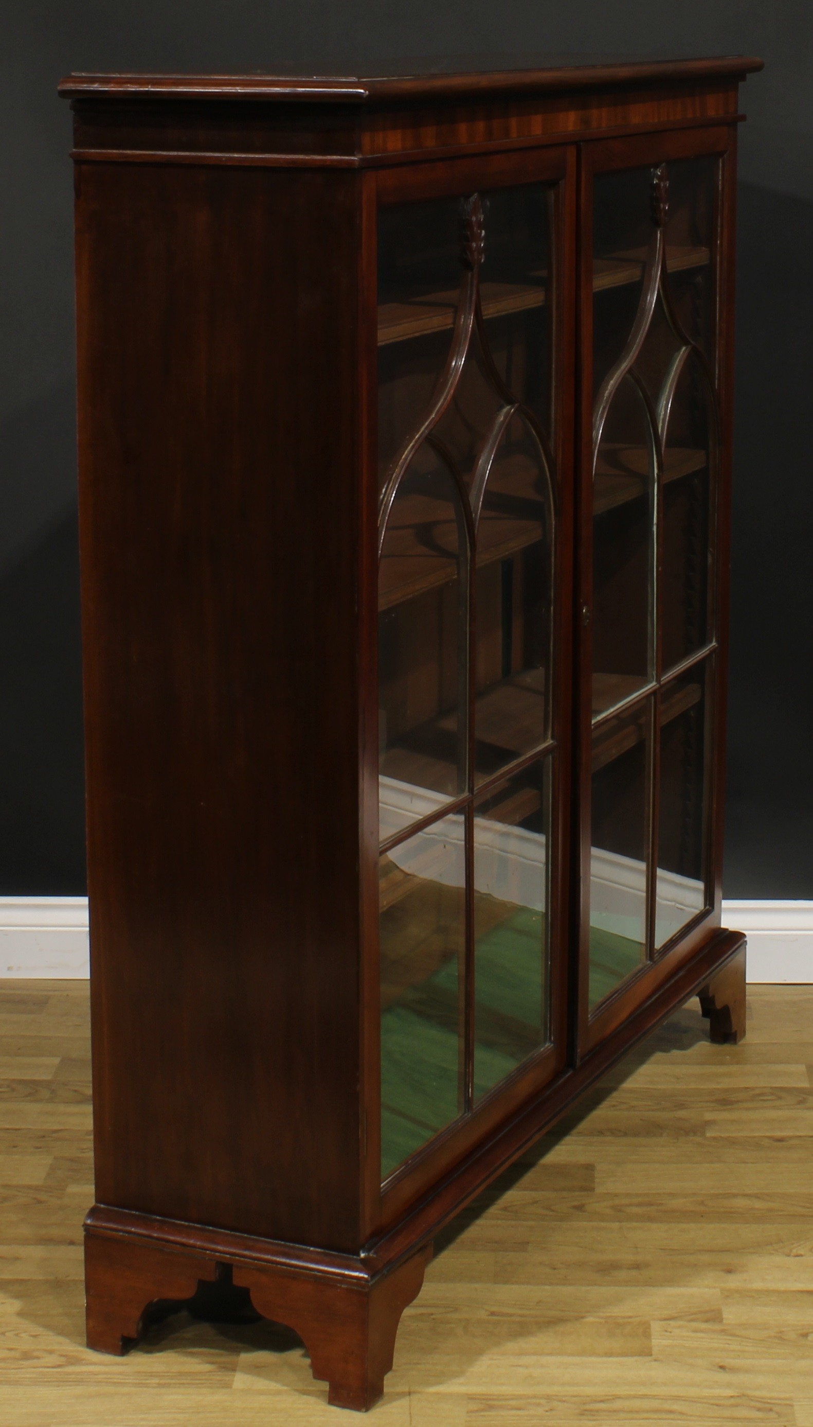 A 19th century mahogany low library bookcase, oversailing top above a pair of glazed doors enclosing - Image 3 of 5
