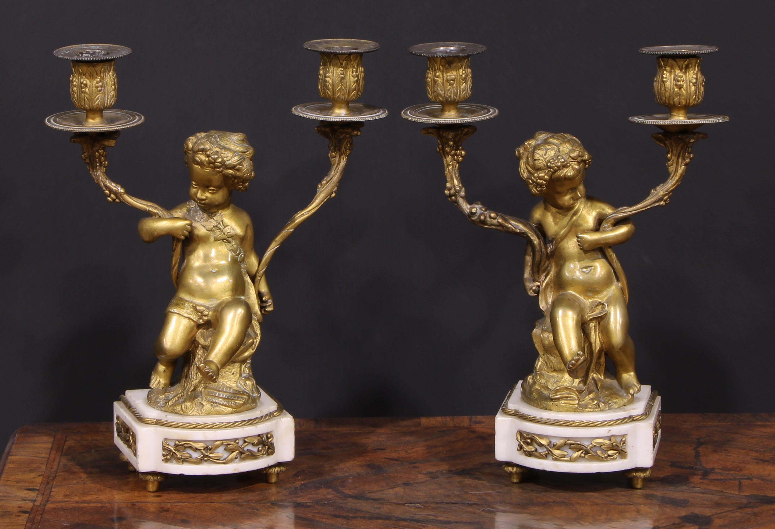 A pair of 19th century French bronze figural two-light candelabra, after Clodion (1738 - 1814),