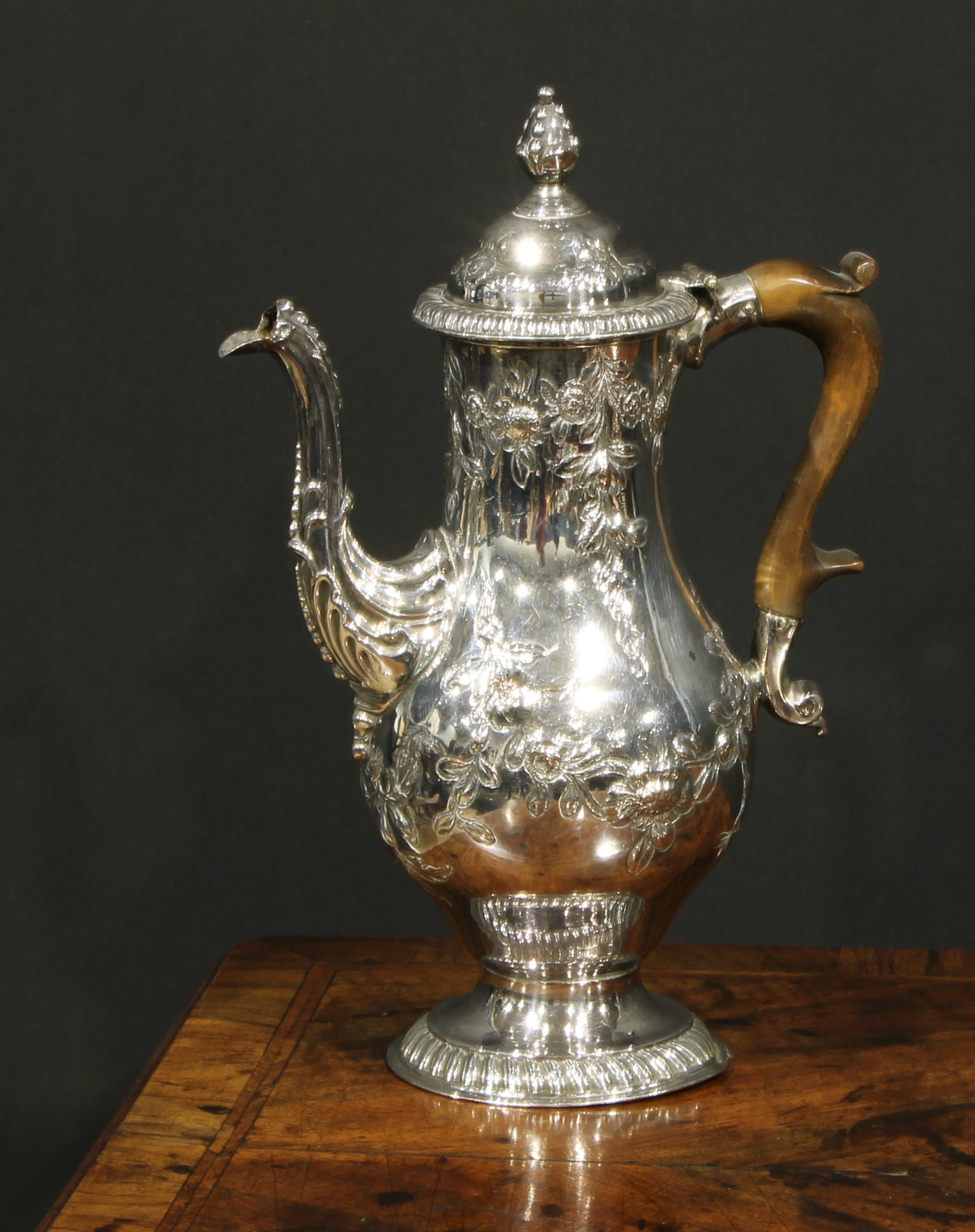 A George III Old Sheffield Plate baluster coffee pot, chased with flowering leafy swags, hinged ogee