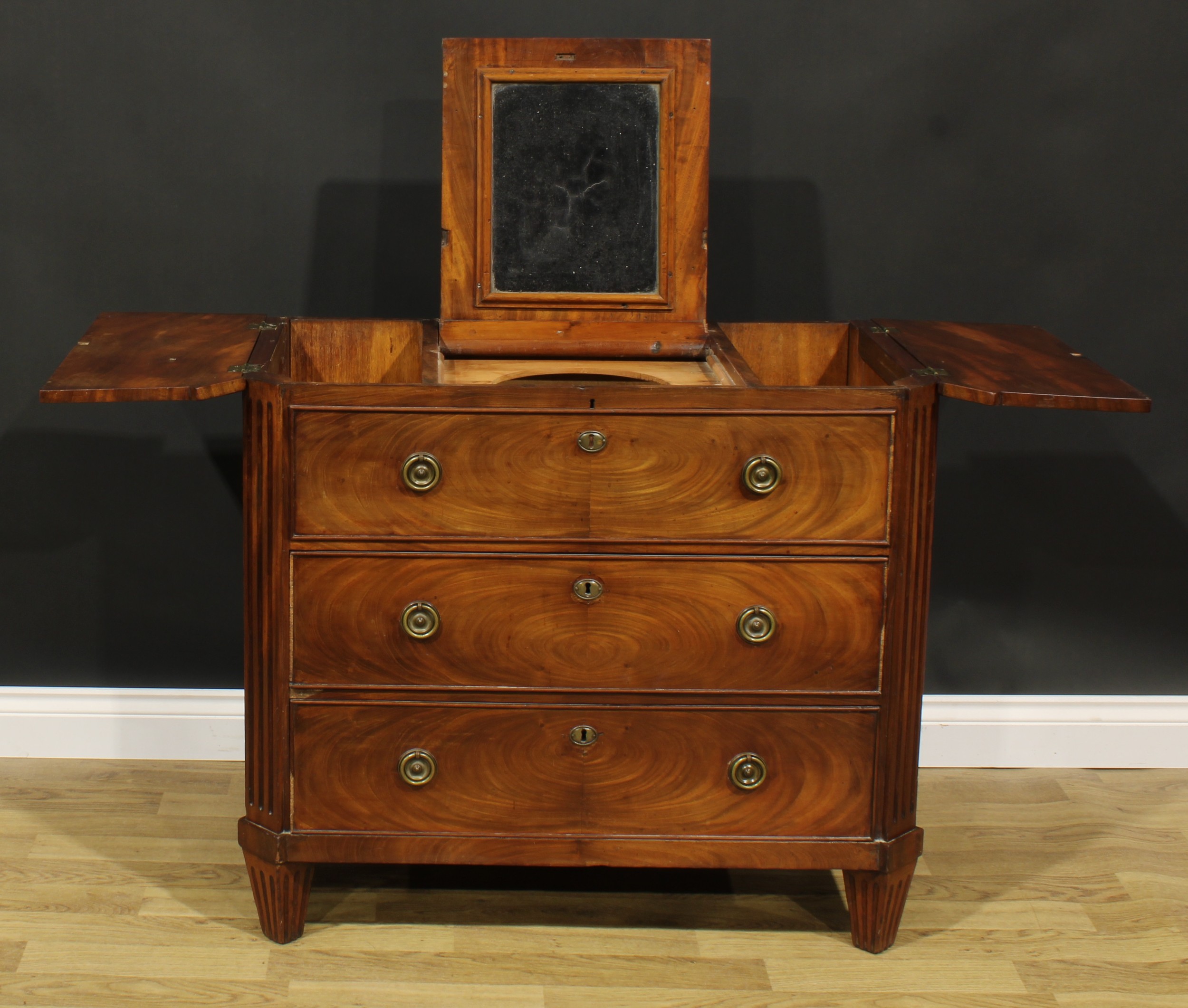 A 19th century Dutch mahogany dressing chest, tripartite hinged top, the centre enclosing a