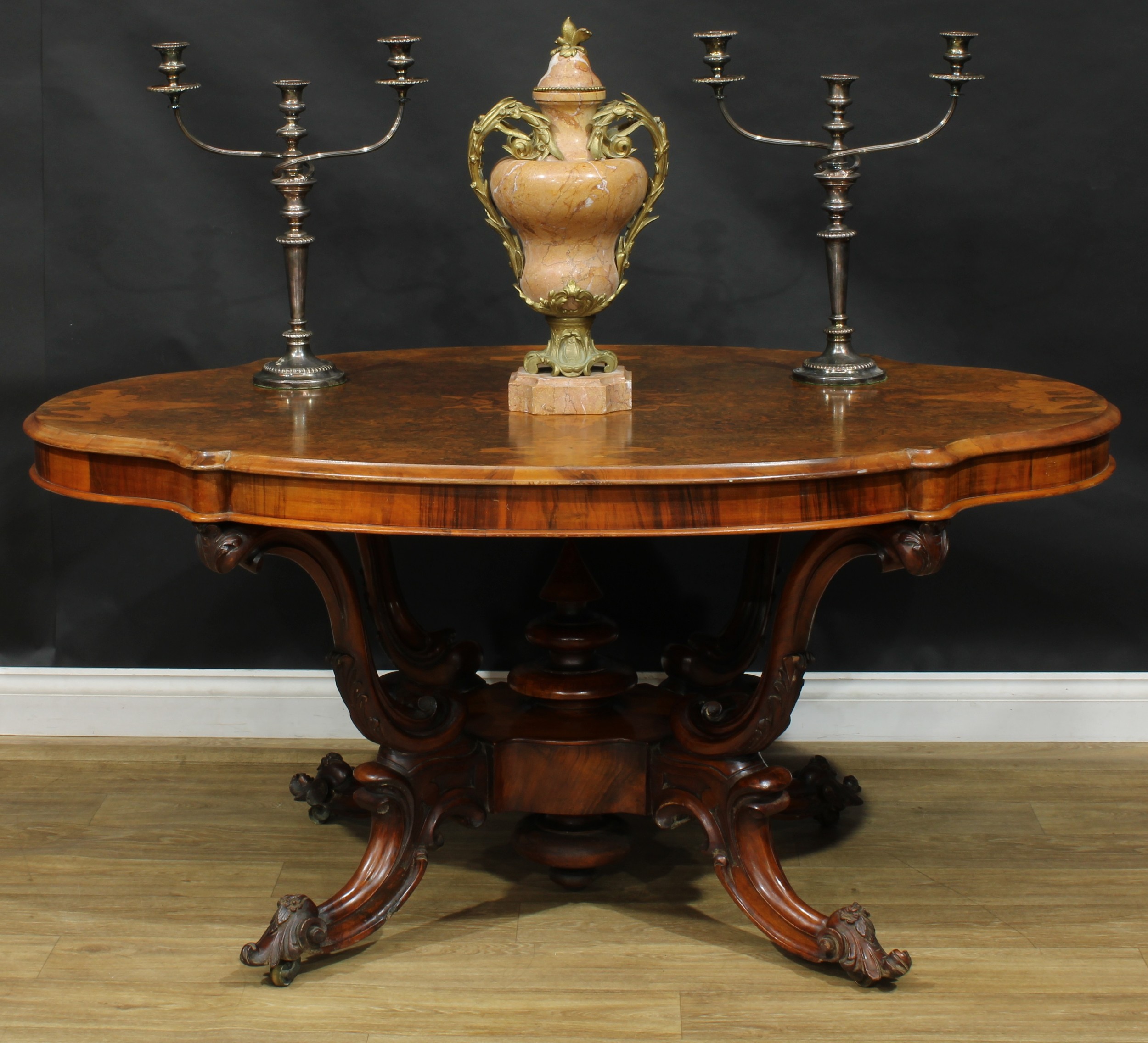 A Victorian walnut basket-base centre table, quarter-veneered burr top with moulded edge, S-scroll