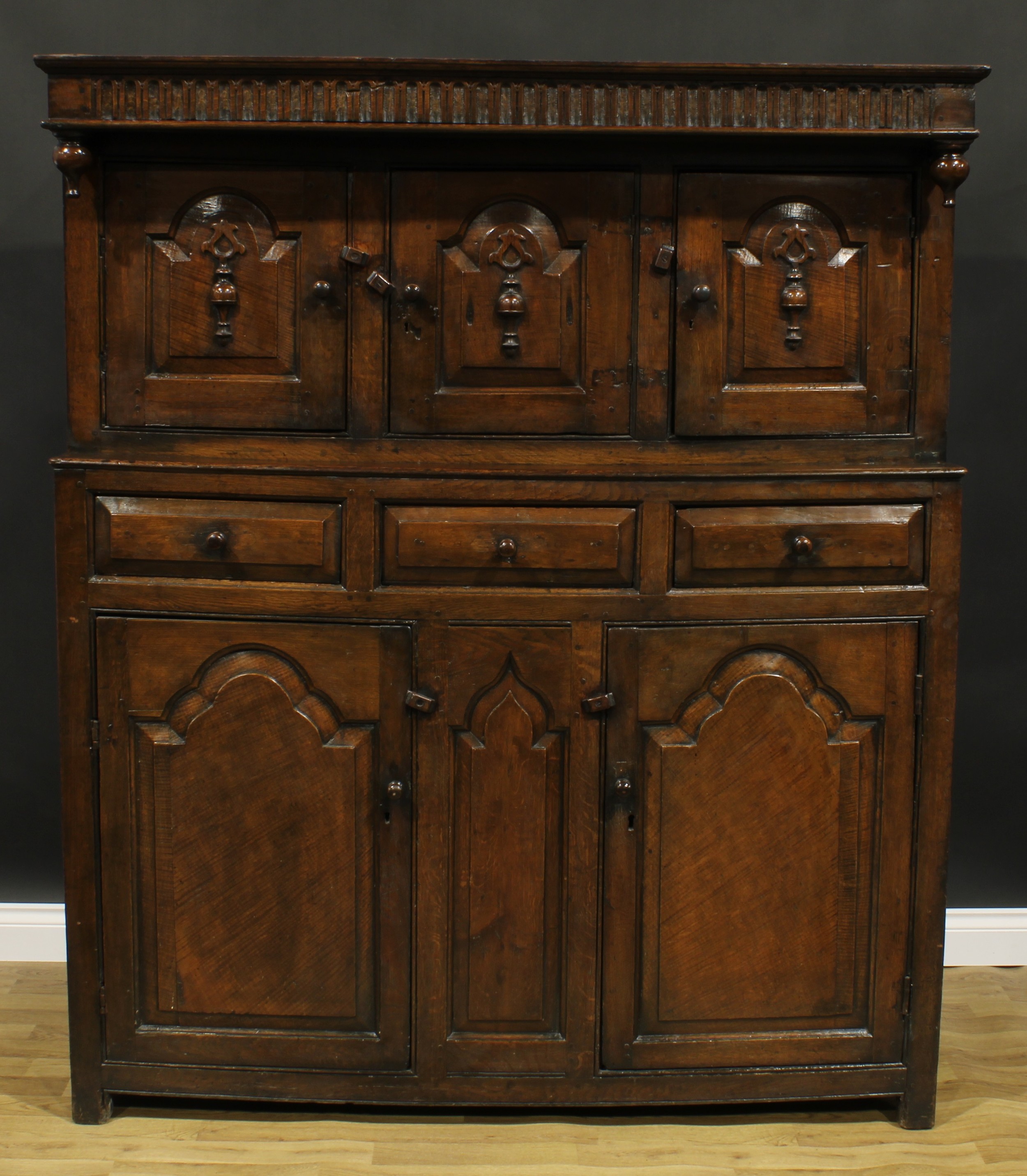 A 17th century style oak duodarn, rectangular top with nulled frieze above three raised and