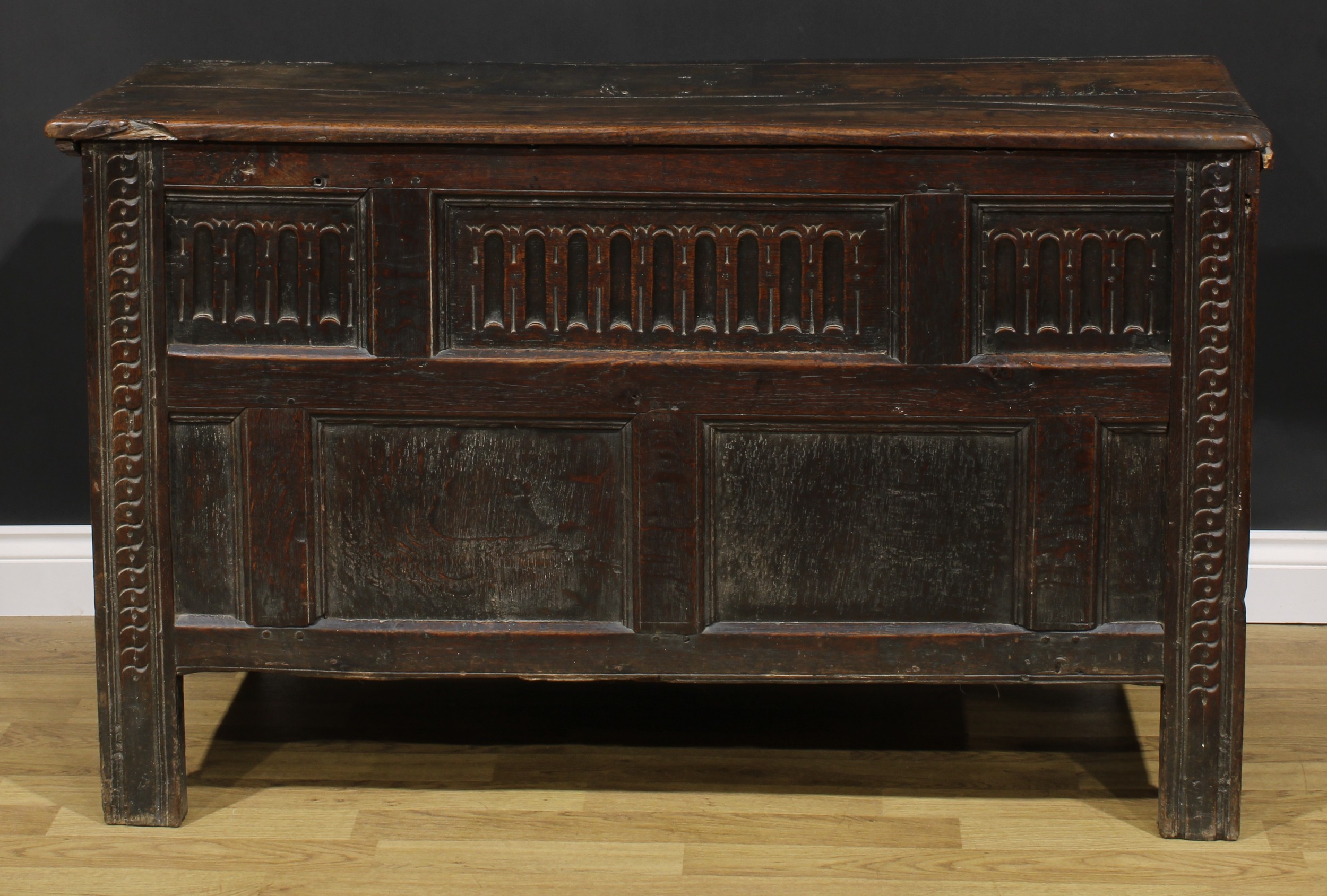 A late 17th century oak blanket chest, hinged top above a nulled panel front, the stiles carved with