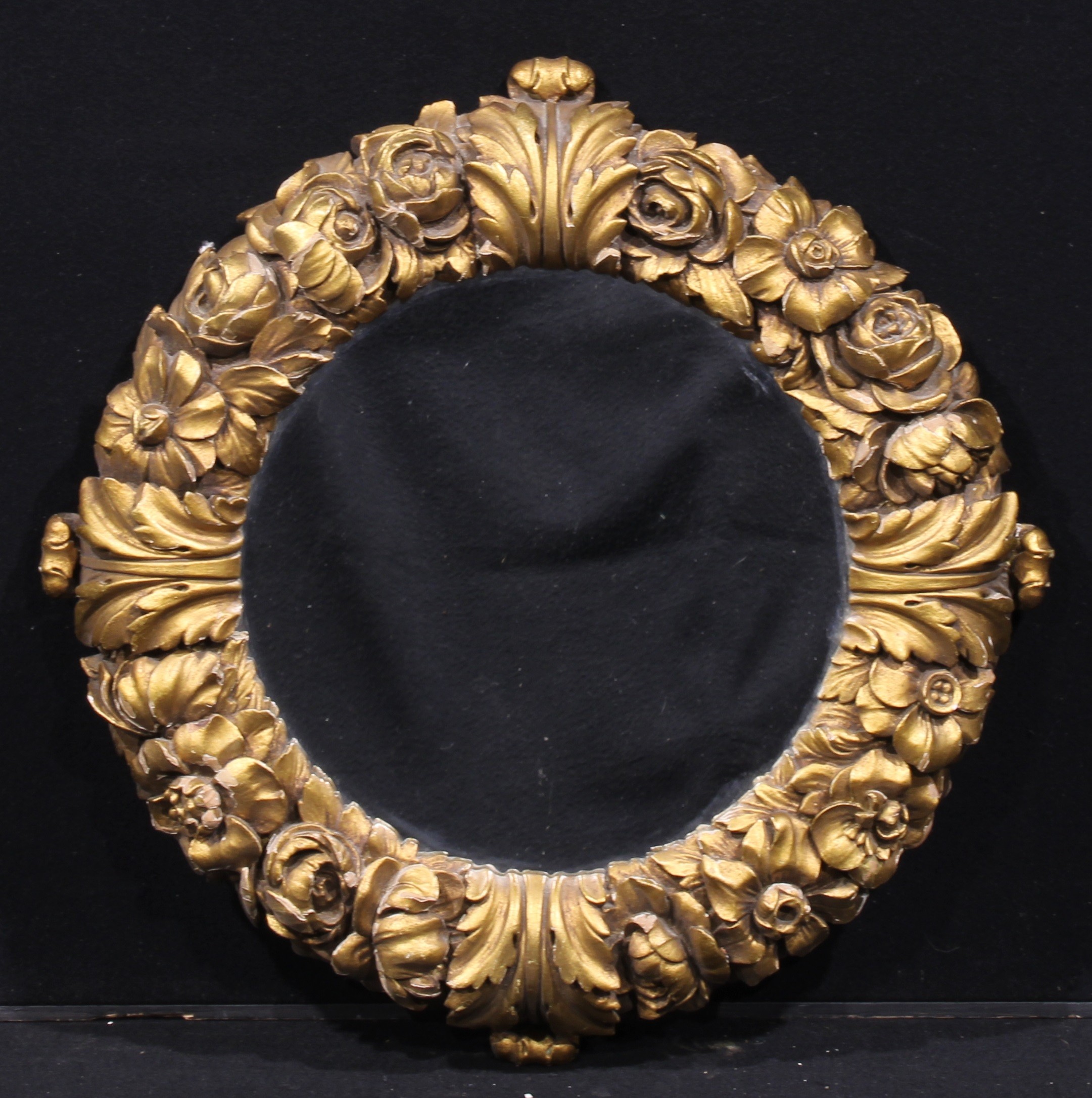 A 19th century giltwood and gesso shaped circular looking glass, plain mirror plate, the frame