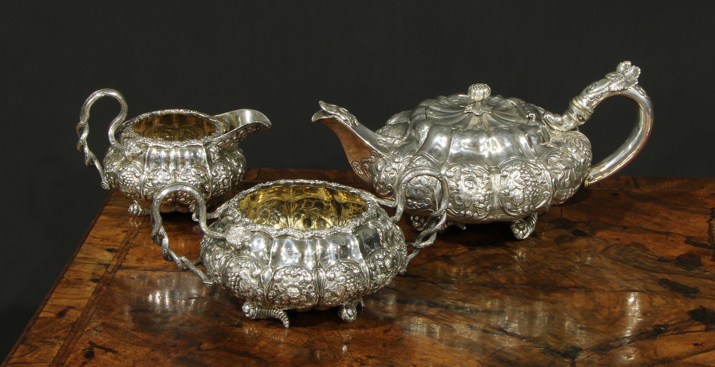 A George IV silver three piece melon shaped tea service, comprising teapot, milk jug and sugar