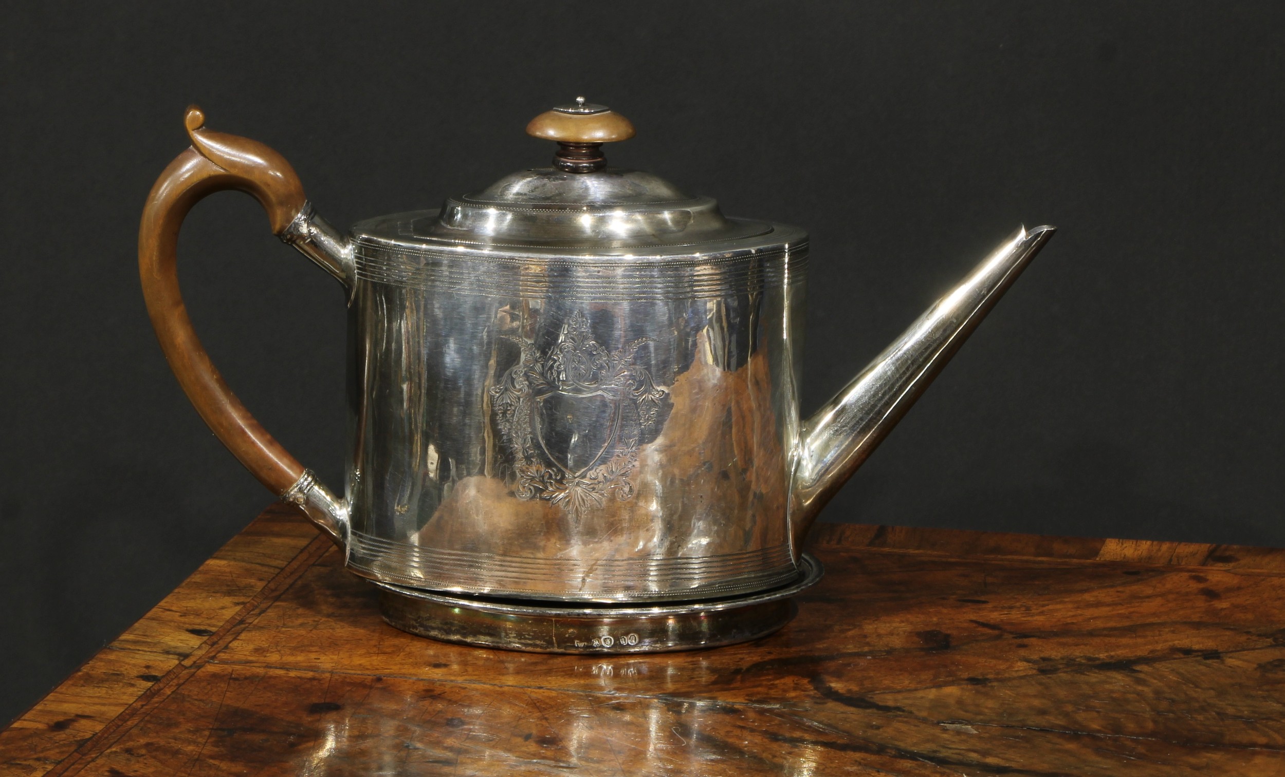 A George III silver oval drum shaped teapot, bright-cut and wrigglework engraved with bands and