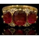 A diamond, garnet and 18ct gold ring, the three large oval facet cut stones divided by smaller round
