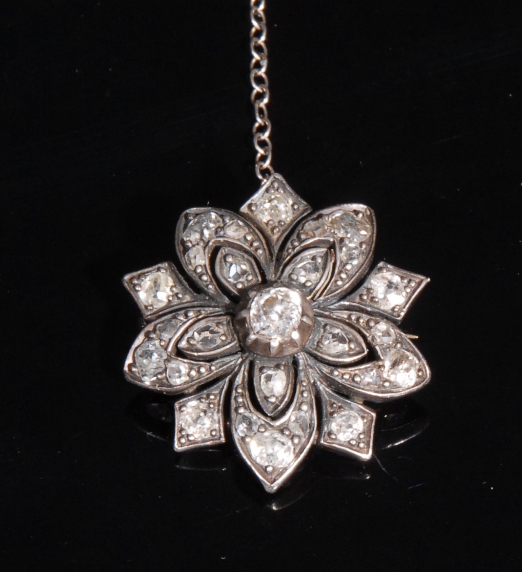 A Victorian diamond flowerhead brooch, the five petals divided by pointed panels, the whole set with