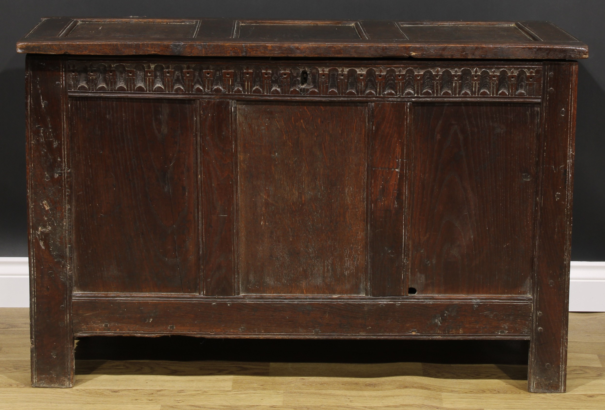 A 17th century oak blanket chest, hinged top, nulled frieze, three panel front, 74cm high, 115cm