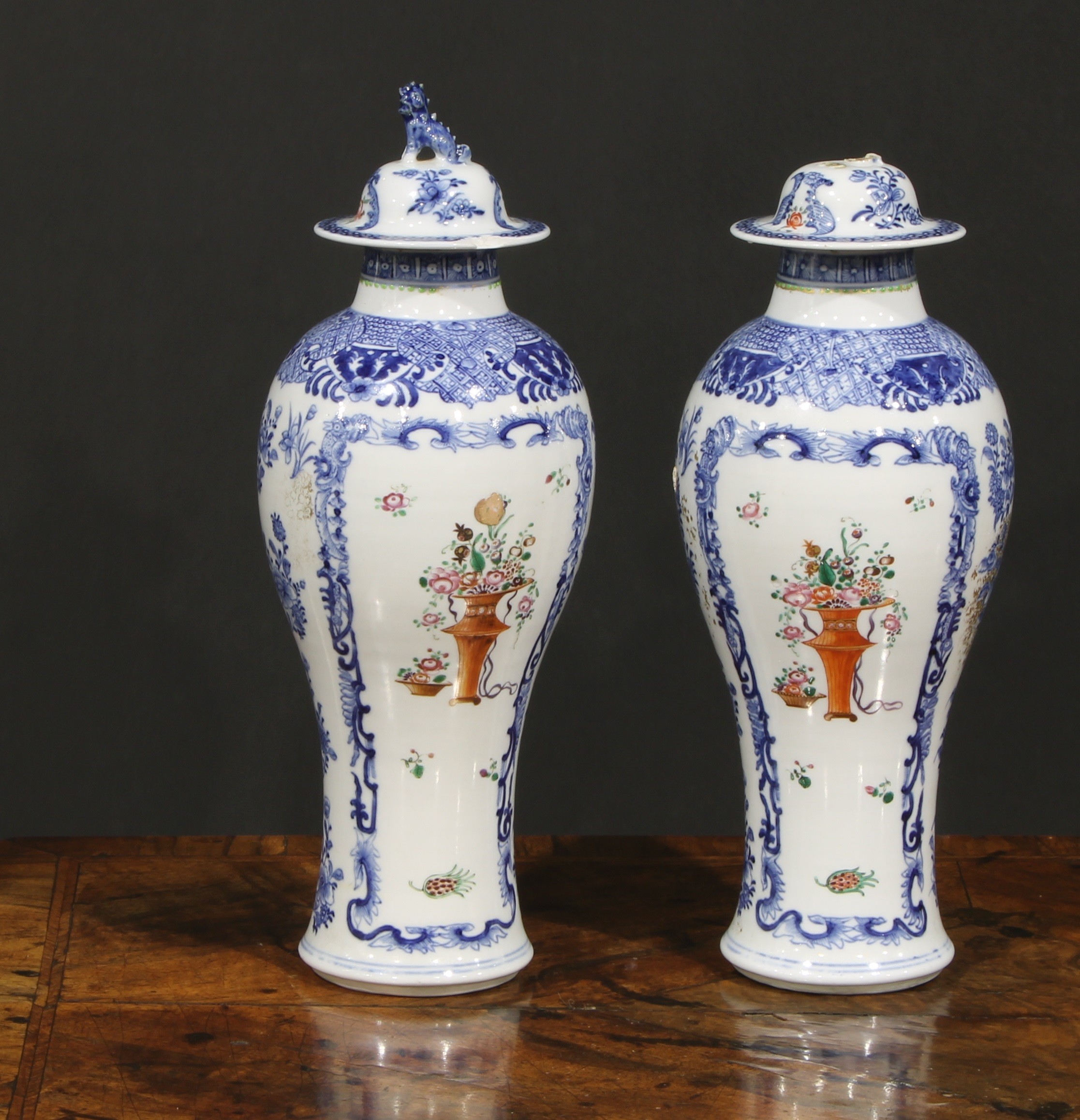 A pair of Chinese baluster vases and covers, painted in the Mandarin palette with vases of flowers