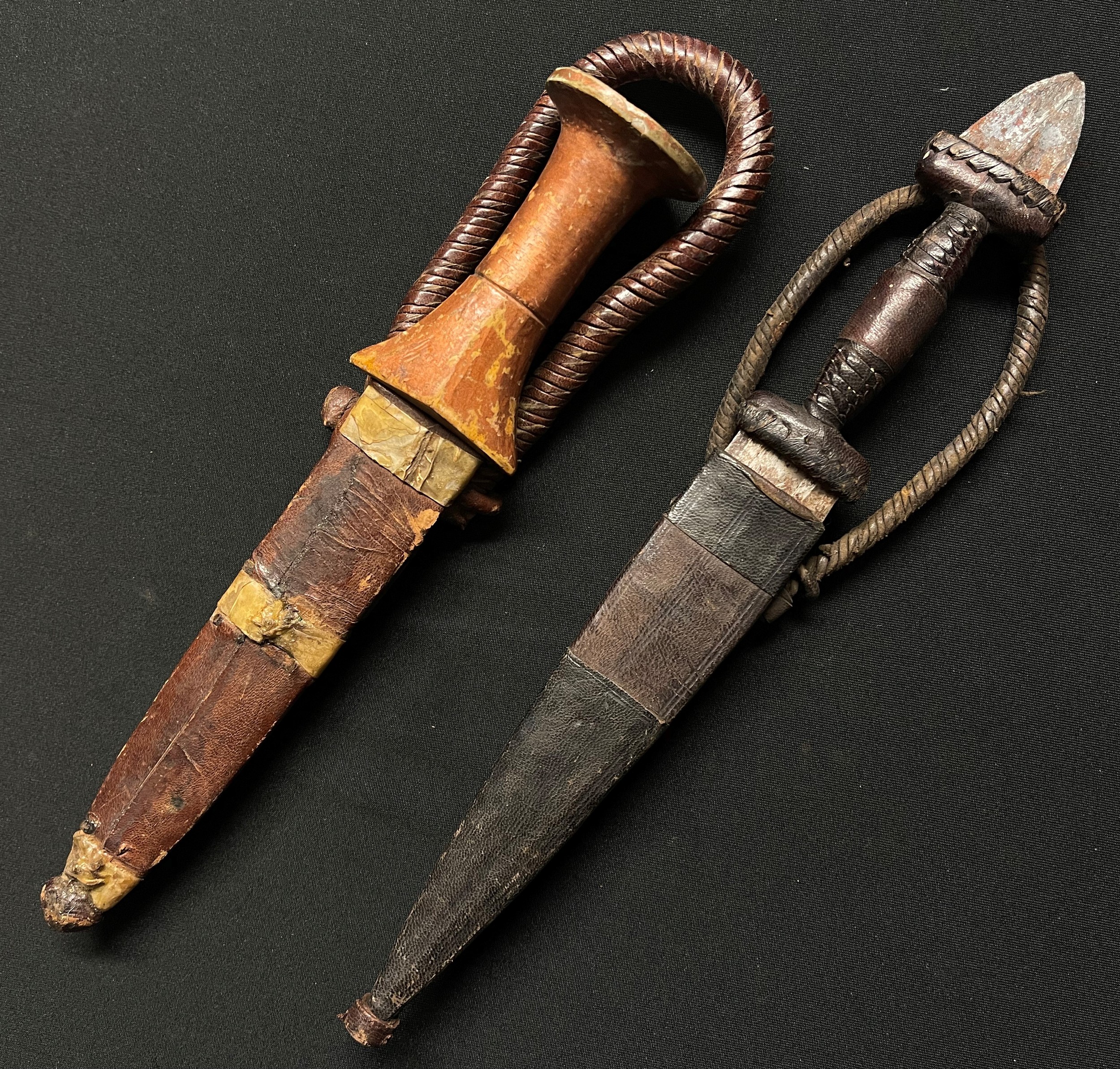 Two African Sleeve Daggers: one with gold painted wooden grip with 134mm long double edged blade,