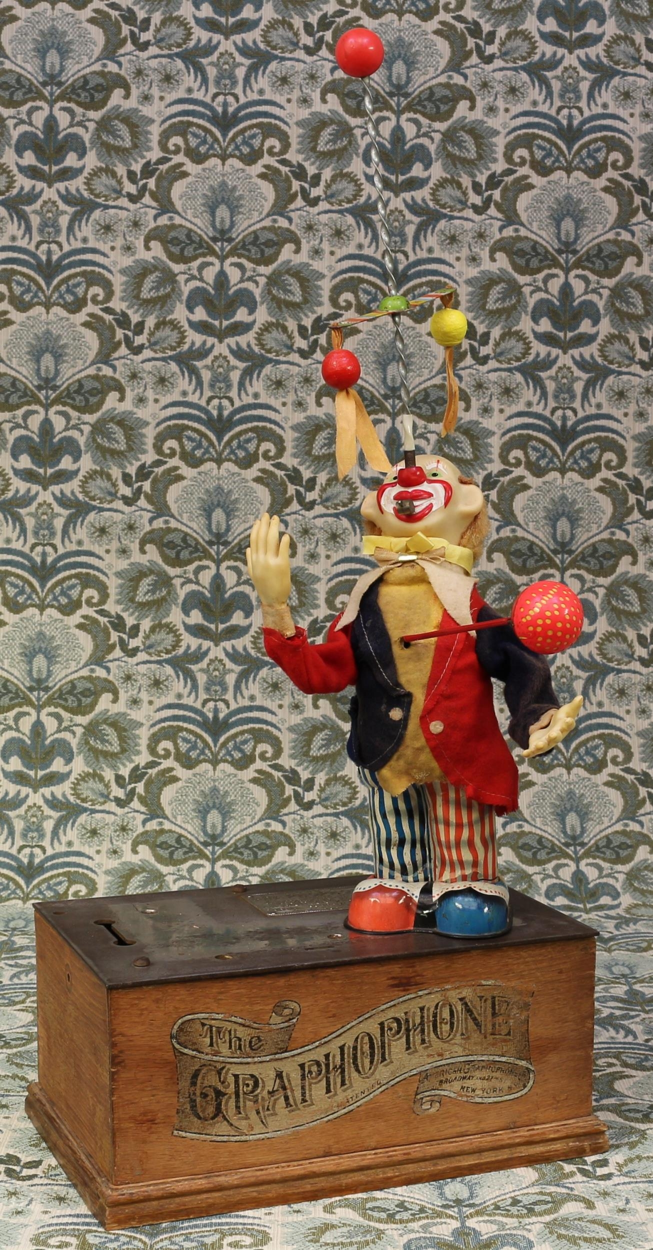 A 1950's Japanese novelty tinplate and battery operated Pinky the juggling clown toy, vinyl head and