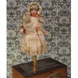 An Armand & Marseille (Germany) bisque shoulder head musical marotte doll and candy container, the