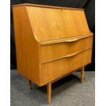 A 1960/70 teak bureau by Sutcliffe of Todmorden, fall door enclosing fitted interior, above pair