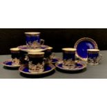 A set of six Edwardian Royal Worcester silver mounted coffee cans and saucers, gilt decoration on