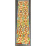 A Turkish Anatolian Kilim runner carpet / rug, woven in tones of blue, green, red, and cream,