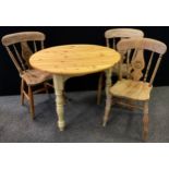 A pine topped cream painted circular kitchen table, 72cm high, 92cm diameter; pair of chairs,