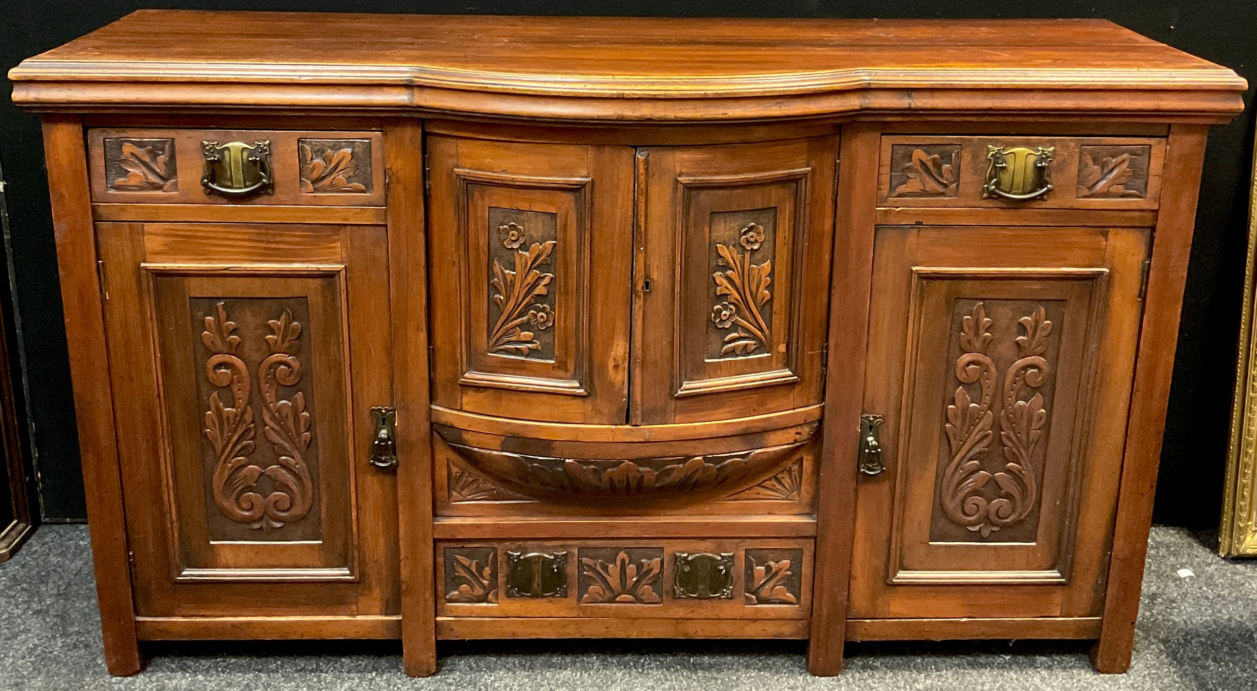 An early 20th century walnut breakfront sideboard, having an arrangement of small drawers and