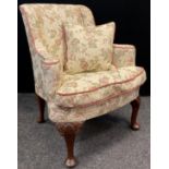 A Victorian walnut wing-back armchair, fully upholstered back and seat, sprung seat, carved cabriole