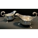 A pair of George V silver sauce boats, piecrust rims, scrolled handles, paw feet, S Blanckensee &