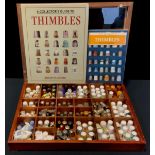 A collection of thimbles in a table top display case, various designs and materials including a