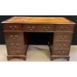 A 20th century reproduction pedestal desk, mahogany veneered, tan leather inset writing surface,