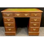 An early 20th century oak pedestal desk, green leather inset writing surface, two short, and one