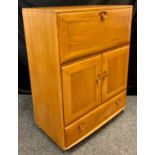 An Ercol ‘Windsor’ model 469 Elm bureau cabinet, 109cm high x 82.5cm wide x 44cm.