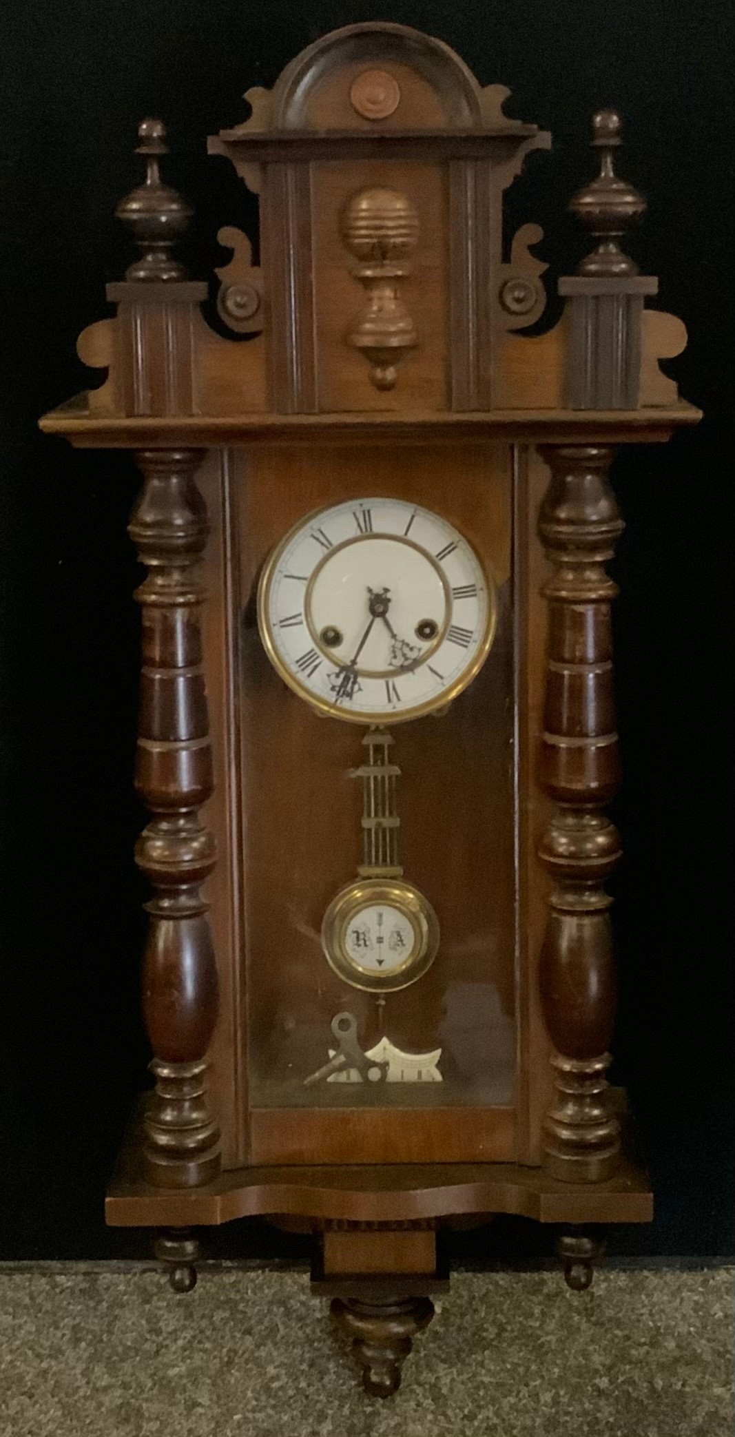 An early 20th century Vienna wall clock, white dial, bold Roman numerals, arched architectural