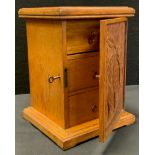 An Arts and Crafts oak table top cabinet, carved door enclosing three drawers, c.1900