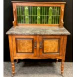 An early 20th century walnut Art Nouveau tile-back washstand, fossil stone top, over pair of