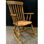 A stained beechwood lathe-back rocking chair, out swept arms, turned supports, double H-stretcher,