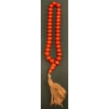 A cherry amber resin prayer bead necklace, shaped toggle, tassel fringe, 48cm long