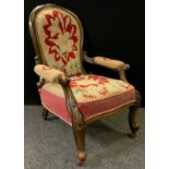 A Victorian walnut spoon-back nursing chair, carved top, scroll arms, upholstered seat, back, and