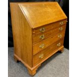 A 19th / early 20th century, George III style reproduction oak bureau, fall door to top enclosing