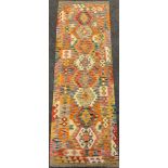 A Turkish Anatolian Kilim runner carpet / rug, knotted in bright tones of red, jade green, yellow,