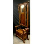 An early 20th century oak hall stand, mirrored back with hinged seat below, approx. 180cm high