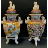 A pair of Japanese Satsuma pottery temple jars and covers, painted with traditional figural and
