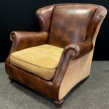 A contemporary tan leather and fabric wingback armchair, scroll arms, turned feet, 92cm high x