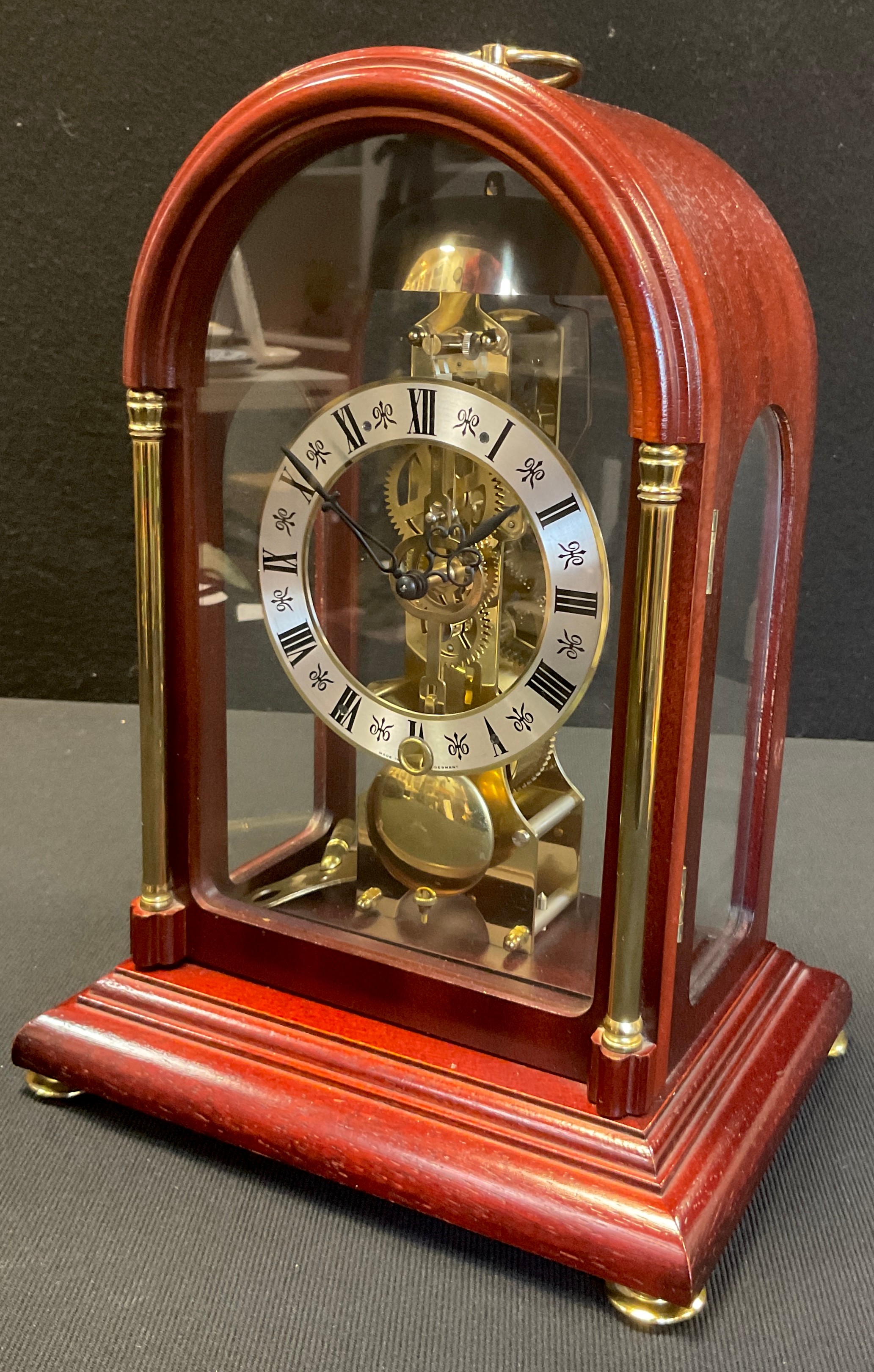 A Hermle mahogany cased skeleton clock, domed case, silvered dial, Roman numerals, mechanical