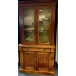 A late Victorian mahogany side cabinet/bookcase, glazed two door top, above single frieze drawer and